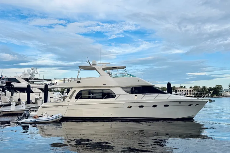 Slide: The Image of 2005 Carver 56 Voyager yacht docked at marina under blue sky. - 2