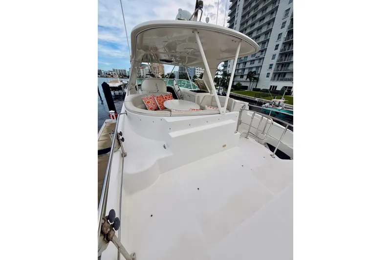 Slide: The Image of 2005 Carver 56 Voyager yacht with spacious deck and seating, docked near waterfront buildings. - 57