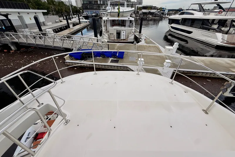 Slide: The Image of 2005 Carver 56 Voyager yacht docked at marina with surrounding boats and walkways. - 58