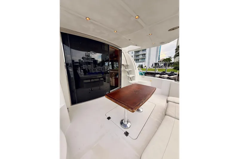 Slide: The Image of 2005 Carver 56 Voyager yacht deck with elegant wooden table and seating area. - 11