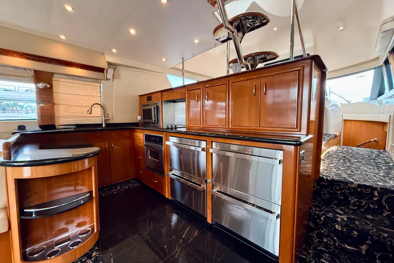 Slide: The Image of Luxurious kitchen interior of 2005 Carver 56 Voyager yacht with wood cabinetry and modern appliances. - 24