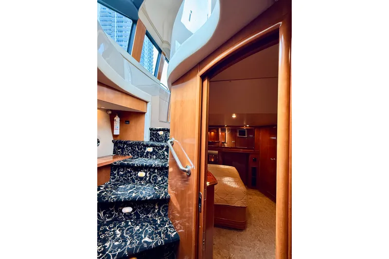 Slide: The Image of Interior view of 2005 Carver 56 Voyager yacht, featuring elegant staircase and cozy bedroom. - 53