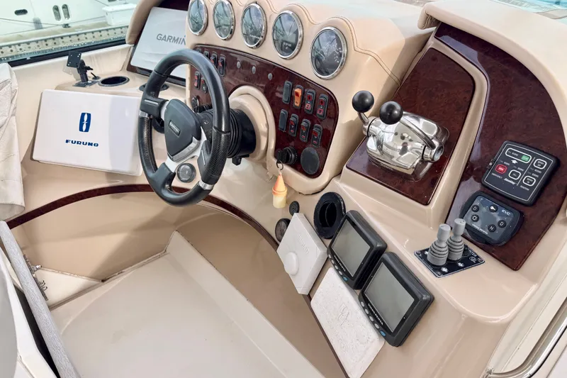 Slide: The Image of 2005 Carver 56 Voyager helm with steering wheel, navigation instruments, and control panels. - 68