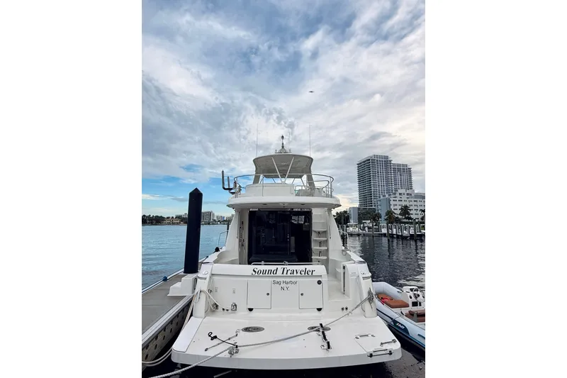 Slide: The Image of 2005 Carver 56 Voyager yacht docked at marina, city skyline in background. - 4
