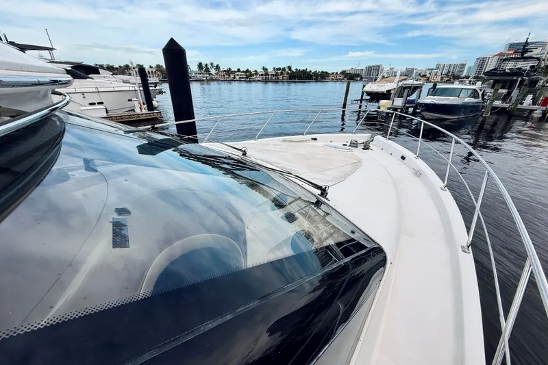 Slide: The Image of 2005 Carver 56 Voyager yacht docked at marina with cityscape background. - 16