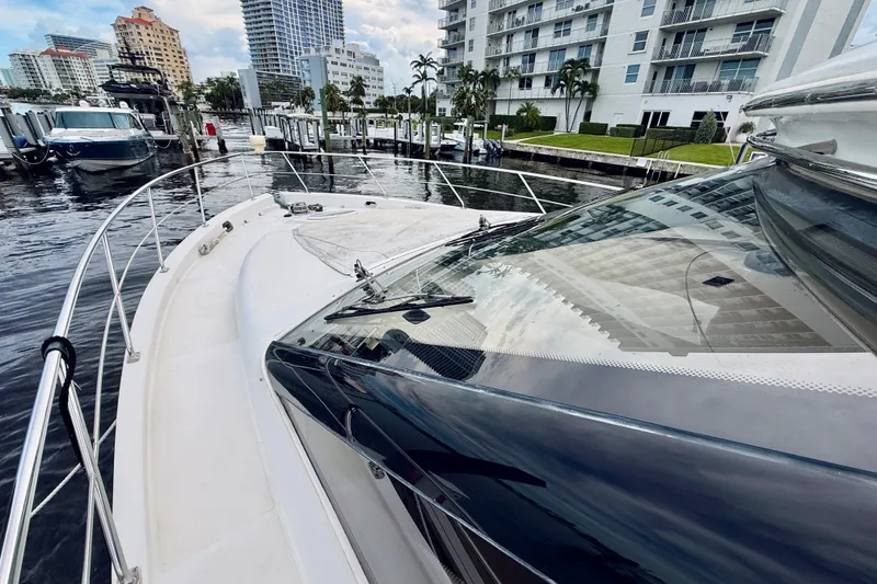 Slide: The Image of 2005 Carver 56 Voyager yacht docked in a marina, surrounded by modern buildings. - 17