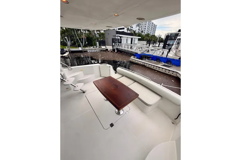 Slide: The Image of 2005 Carver 56 Voyager yacht deck with seating and table, docked at marina. - 10