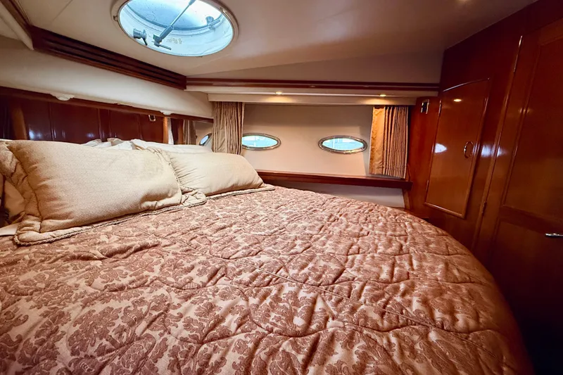 Slide: The Image of Luxurious bedroom interior of 2005 Carver 56 Voyager yacht with elegant bedding and porthole windows. - 47
