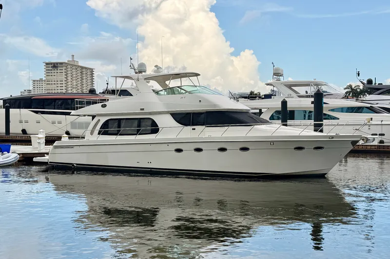 The Image of 2005 Carver 56 Voyager yacht docked in a marina, reflecting on calm water. - 0