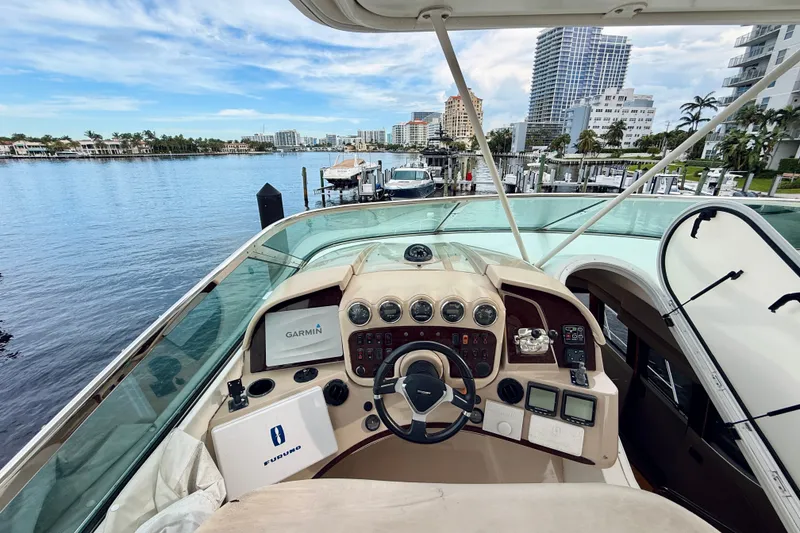 Slide: The Image of Helm of 2005 Carver 56 Voyager yacht with navigation equipment, docked in a scenic marina. - 66