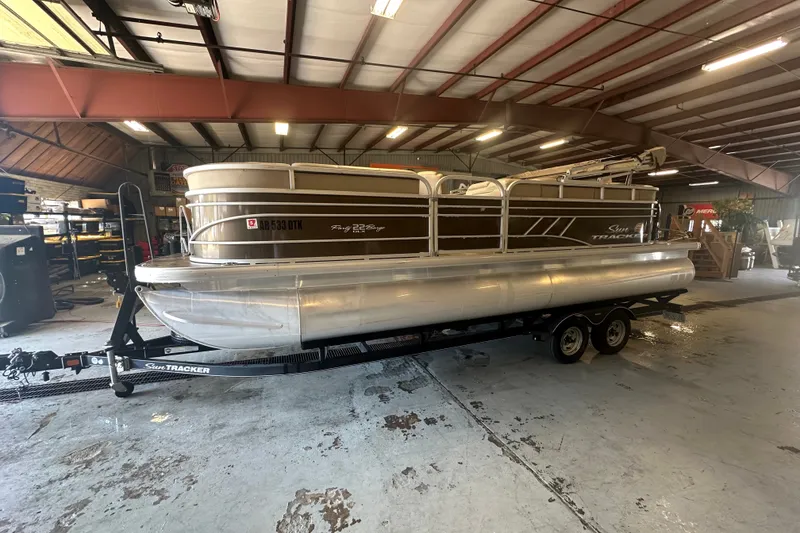 The Image of 2020 Sun Tracker Party Barge 22 DLX pontoon boat on trailer in warehouse. - 0