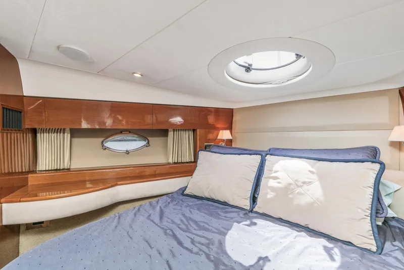Slide: The Image of Luxurious cabin interior of a 2007 Viking Sport Cruiser yacht with elegant bedding and wood accents. - 27