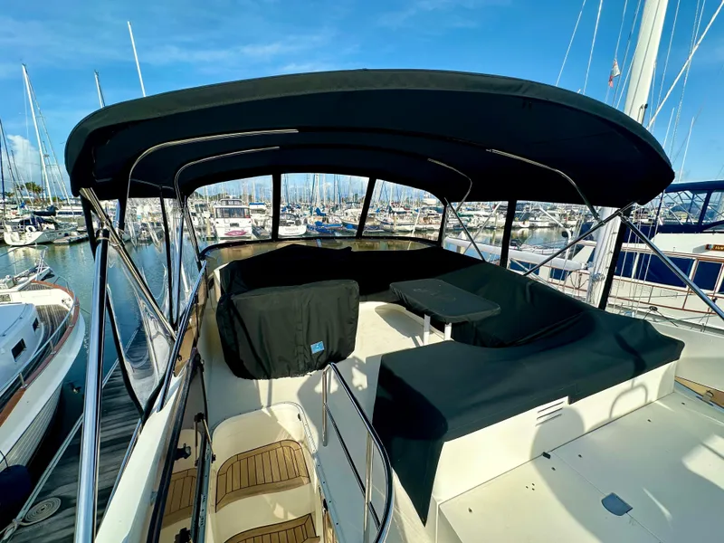 Slide: The Image of 2007 Viking Sport Cruiser with covered deck, docked in a marina under clear blue skies. - 43