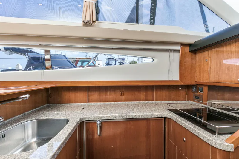 Slide: The Image of Interior of 2007 Viking Sport Cruiser kitchen with wood cabinetry and modern appliances. - 19