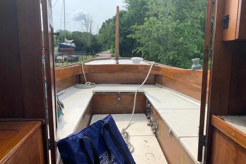 Slide: The Image of Interior view of a 1975 Halberg Rassey P-28 sailboat with wooden seating and ropes. - 25