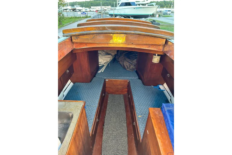 Slide: The Image of Interior of a 1975 Halberg Rassey P-28 sailboat with wooden finish and blue flooring. - 26