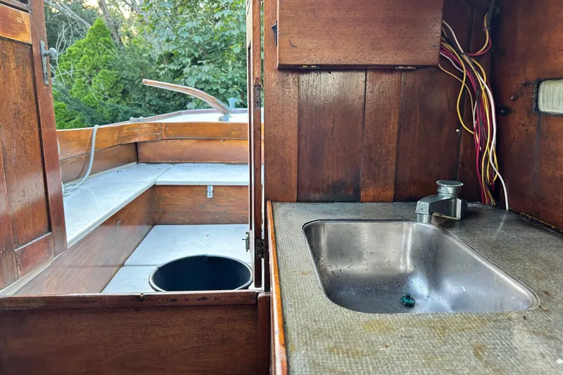 Slide: The Image of Interior of a 1975 Halberg Rassey P-28 boat with wooden cabinetry and a small sink. - 38