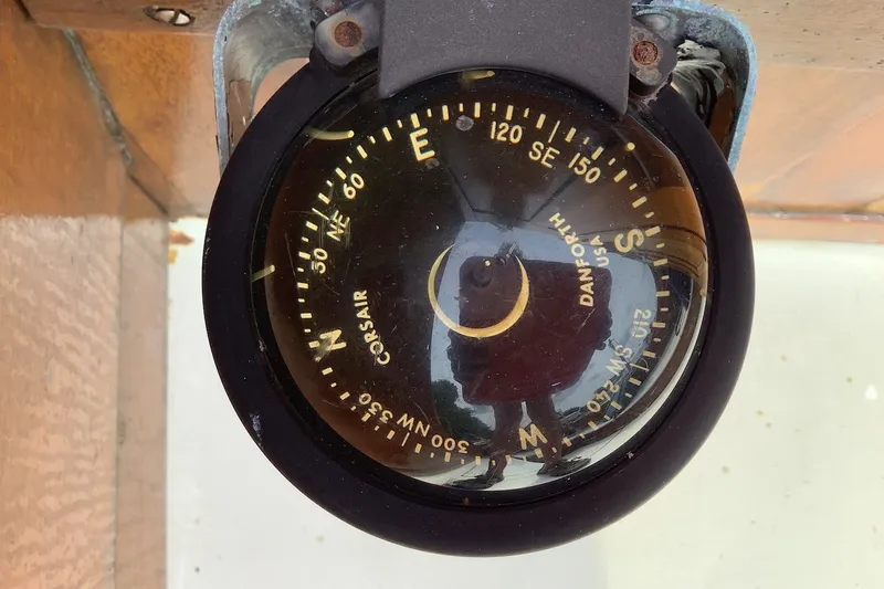 Slide: The Image of Vintage compass on a 1975 Halberg Rassey P-28 sailboat, showing cardinal directions. - 16