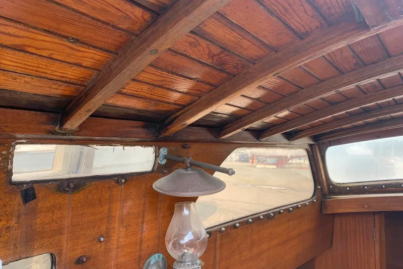 Slide: The Image of Interior of a 1975 Halberg Rassy P 28 with wooden paneling and an antique lamp. - 35