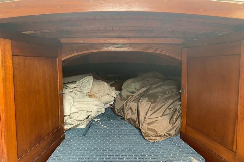 Slide: The Image of Interior storage of 1975 Halberg Rassey P-28 sailboat with wooden cabinets and folded sails. - 31