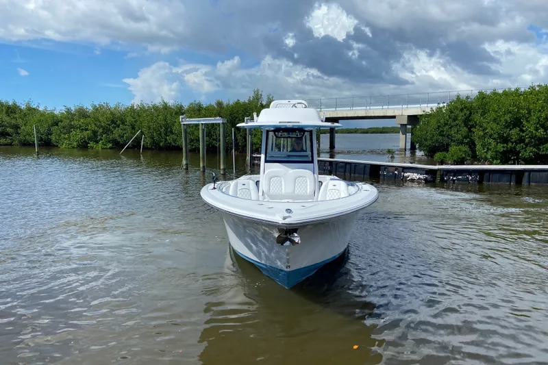 Slide: The Image of 2026 Sportsman Open 302 Center Console boat on calm water near a bridge. - 2