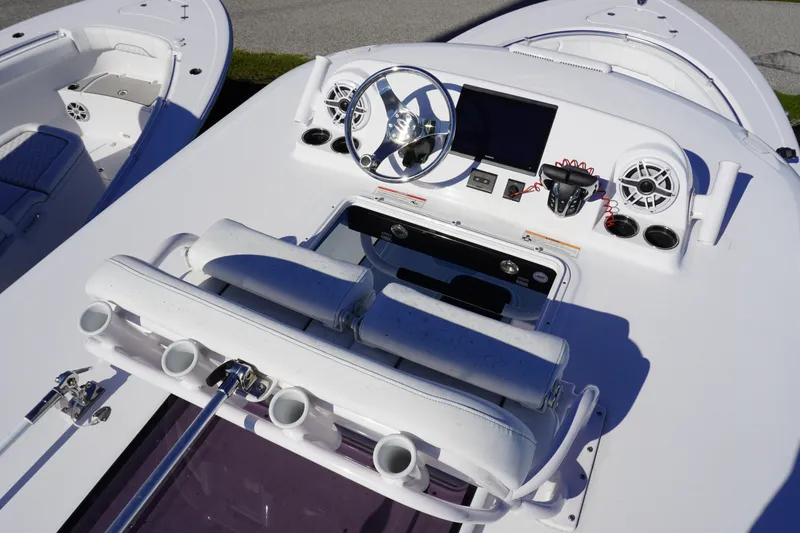 Slide: The Image of 2026 Sportsman Open 302 Center Console boat dashboard with steering wheel and electronic controls. - 26