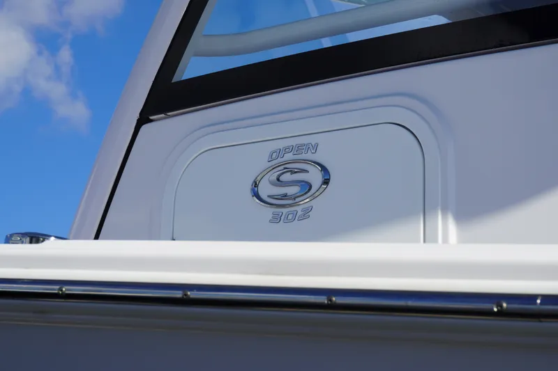 Slide: The Image of 2026 Sportsman Open 302 Center Console boat emblem against blue sky. - 12