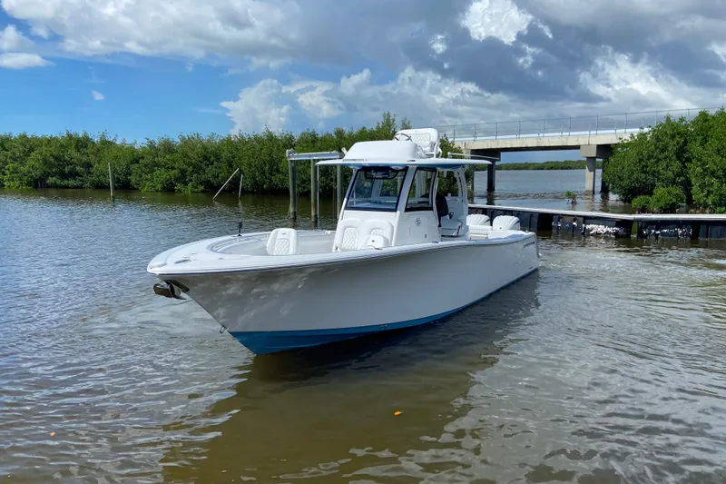 Slide: The Image of 2026 Sportsman Open 302 Center Console boat on calm water near a bridge. - 1