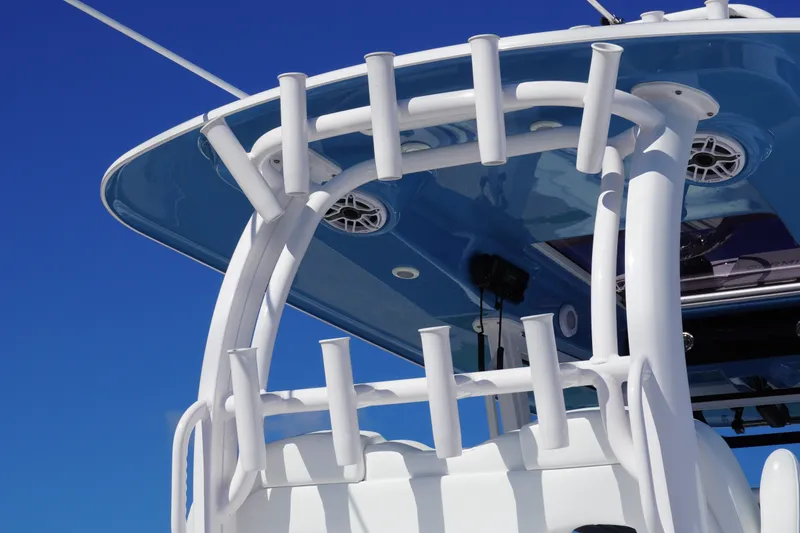 Slide: The Image of 2026 Sportsman Open 302 Center Console boat with rod holders against clear blue sky. - 16