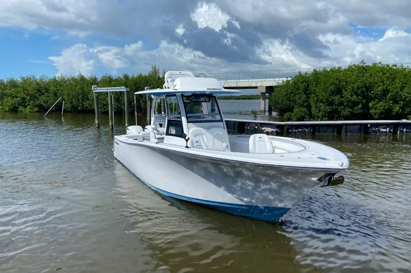 Slide: The Image of 2026 Sportsman Open 302 Center Console boat on calm water under cloudy sky. - 3