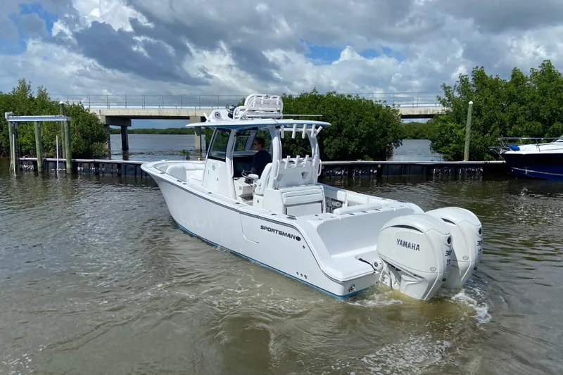 Slide: The Image of 2026 Sportsman Open 302 Center Console boat with Yamaha engines on a scenic waterway. - 7