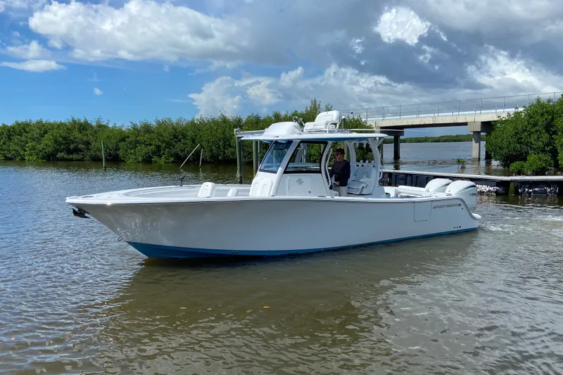 The Image of 2026 Sportsman Open 302 Center Console boat on calm water near a bridge. - 0