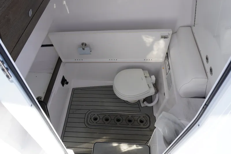 Slide: The Image of 2026 Sportsman Open 302 Center Console boat interior with toilet and flooring. - 31