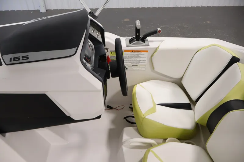 Slide: The Image of Interior of 2016 Scarab 165 G boat with steering wheel and cushioned seats. - 17