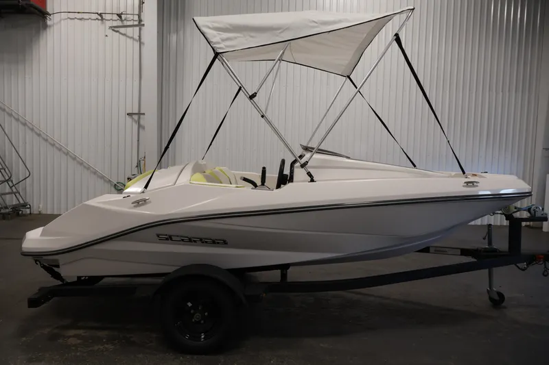Slide: The Image of 2016 Scarab 165 G boat with canopy, displayed indoors on a trailer. - 4