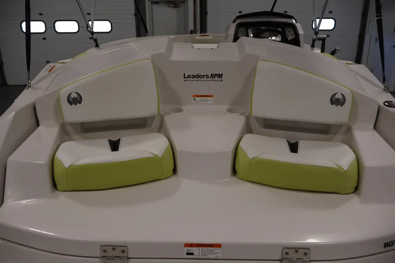 Slide: The Image of 2016 Scarab 165 G boat interior with white and green seating in a garage setting. - 28