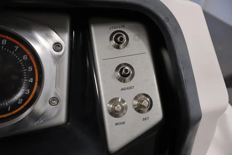 Slide: The Image of Dashboard controls of a 2016 Scarab 165 G boat, featuring dials and switches. - 22