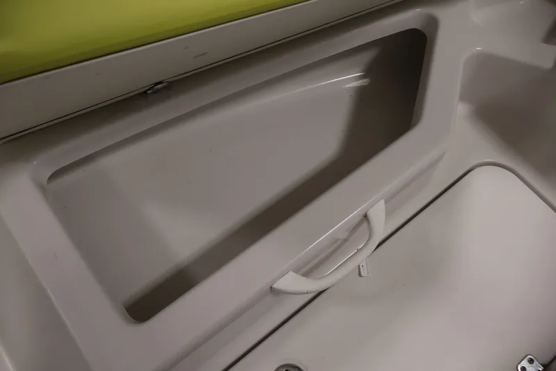 Slide: The Image of Storage compartment in a 2016 Scarab 165 G boat, featuring a white handle. - 14