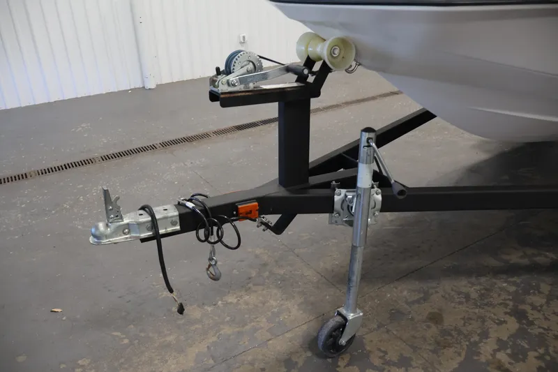 Slide: The Image of Trailer hitch and support wheel of a 2016 Scarab 165 G boat in a garage. - 31