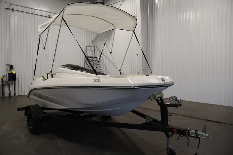 Slide: The Image of 2016 Scarab 165 G boat with canopy on trailer in indoor storage. - 3