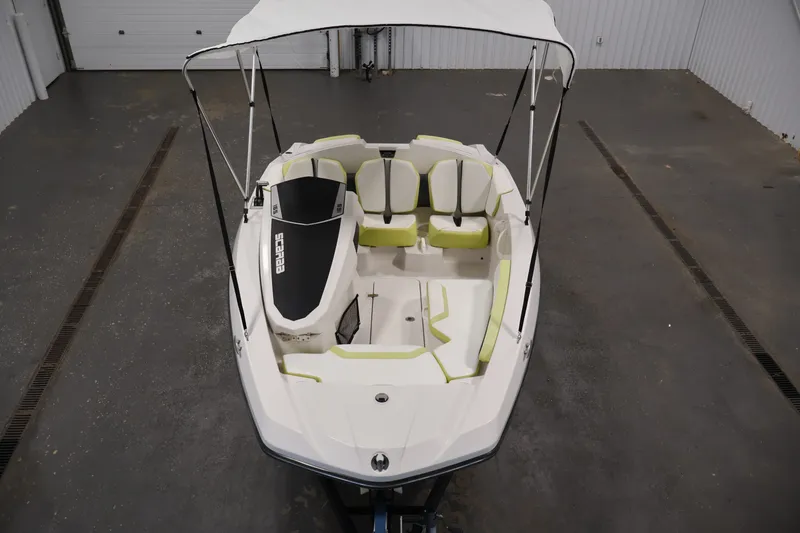 Slide: The Image of 2016 Scarab 165 G boat with canopy, white and green seating, in a garage setting. - 9