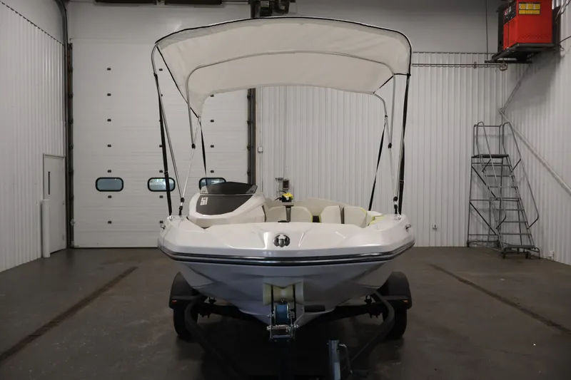 Slide: The Image of 2016 Scarab 165 G boat with canopy in indoor storage facility. - 2
