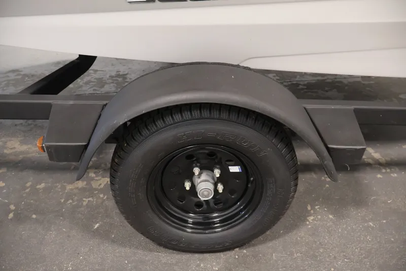 Slide: The Image of Trailer wheel of a 2016 Scarab 165 G boat, featuring a black tire and fender. - 33