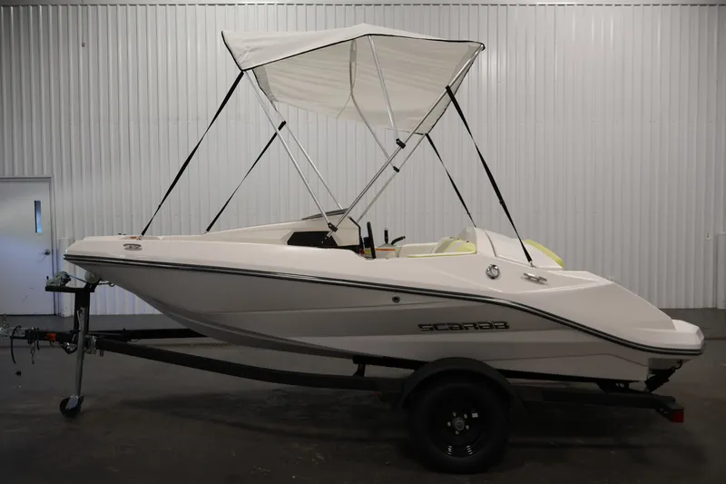 Slide: The Image of 2016 Scarab 165 G boat with canopy on trailer in indoor setting. - 8
