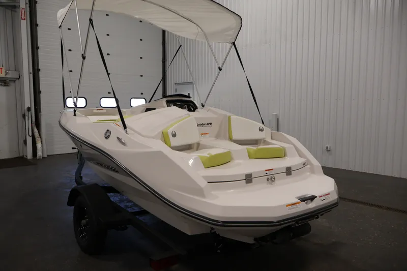 Slide: The Image of 2016 Scarab 165 G boat with canopy, displayed indoors on a trailer. - 7