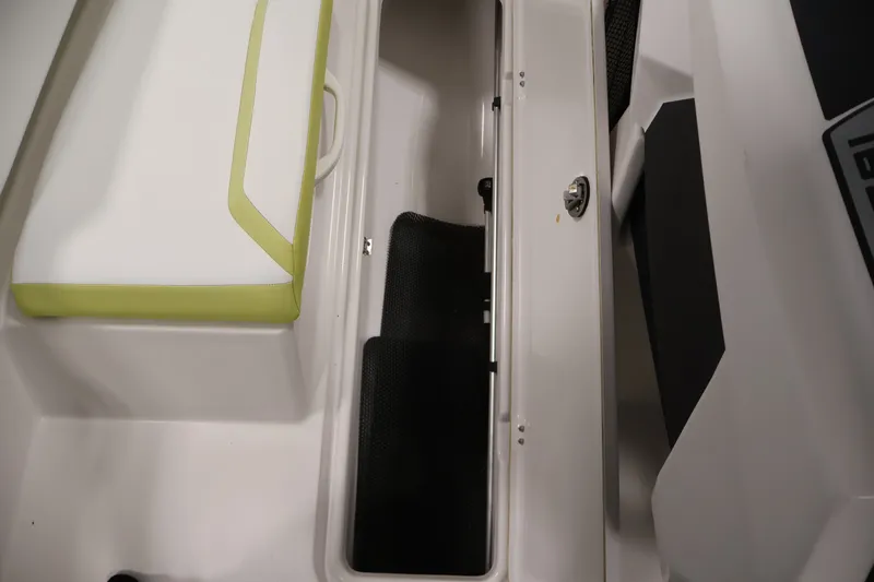 Slide: The Image of Interior storage compartment of a 2016 Scarab 165 G boat with cushioned seating. - 16