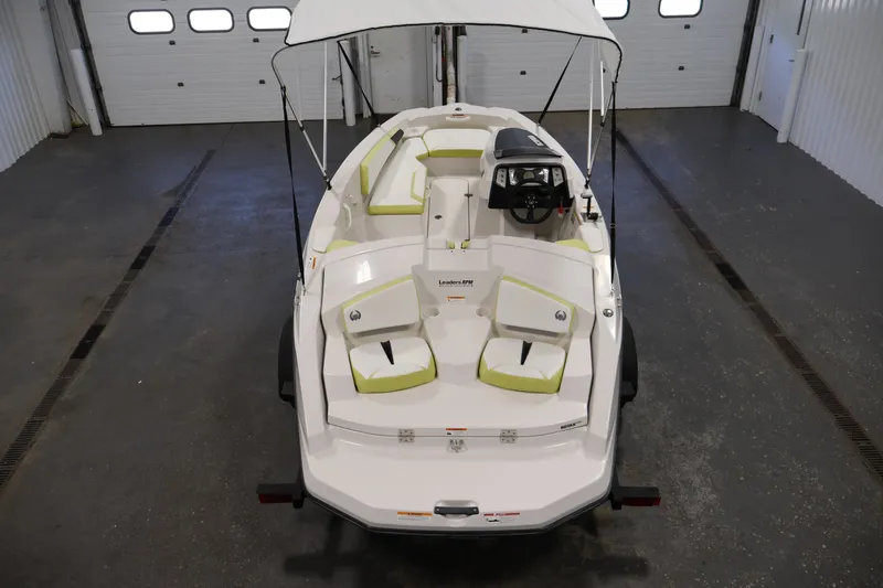 Slide: The Image of 2016 Scarab 165 G boat with canopy, white and green seating, in a garage setting. - 10