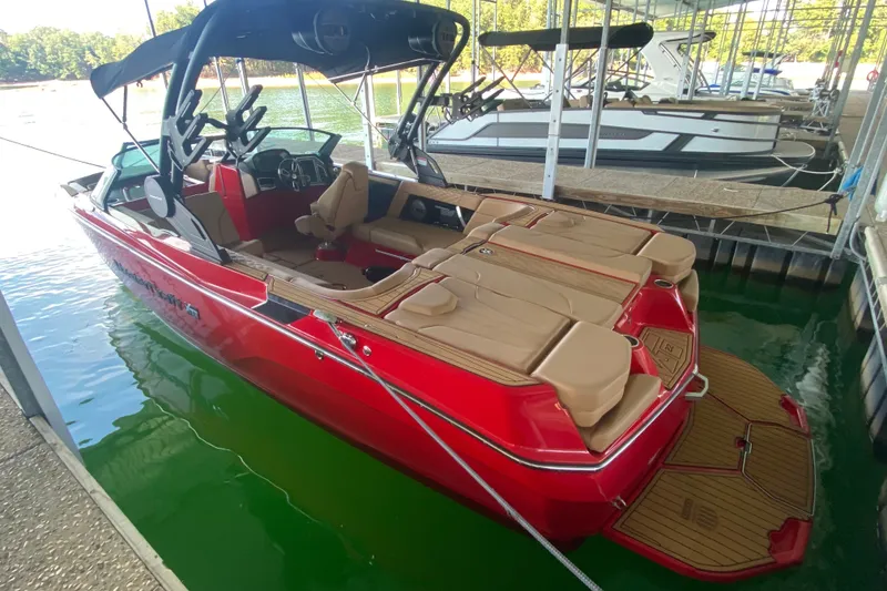 The Image of 2024 MasterCraft XT22 boat in vibrant red docked at a marina. - 0