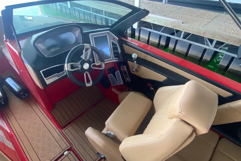 Slide: The Image of 2024 MasterCraft XT22 boat interior with modern dashboard and beige seating. - 7