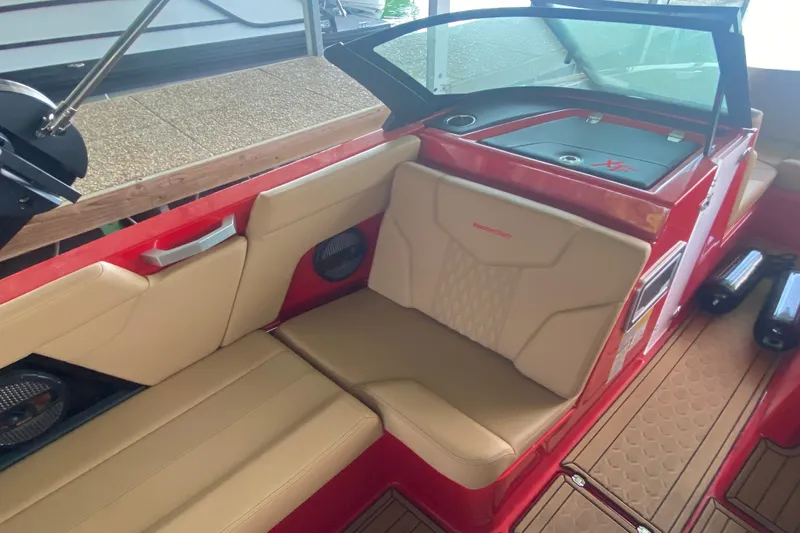 Slide: The Image of 2024 MasterCraft XT22 boat interior with beige seating and red accents. - 8